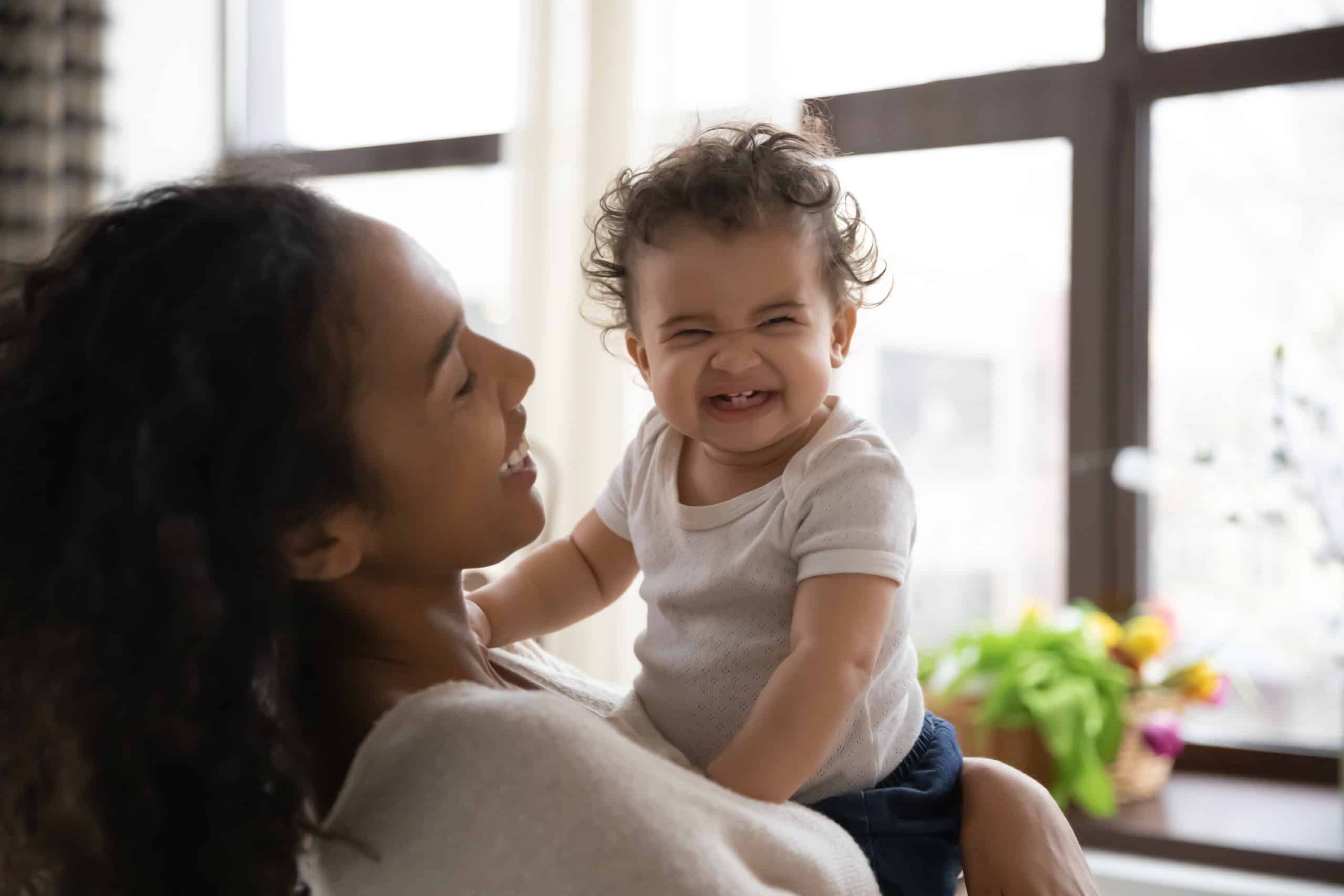 Young Biracial Mom Play With Smiling Little Baby Girl